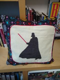 Darth Vader pillow Counted cross stitch of Darth Vader with light saber extended, on a pillow of Star Wars print
