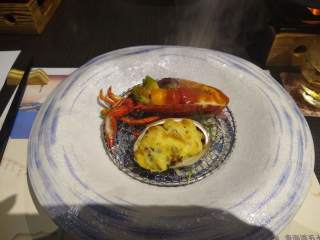 Fish course Abalone in the shell and a small lobster - fish course from a fancy Japanese dinner
