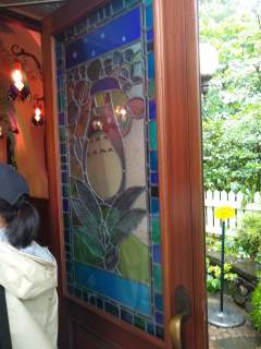 Ghibli Museum stained glass doors The front door of the Studio Ghibli museum, featuring a stained glass Totoro
